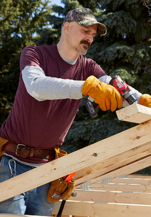 Construction worker building wooden framing on a house